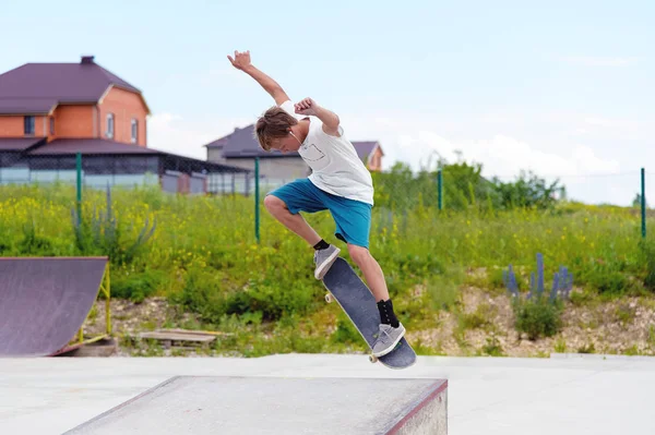 Een jongen in een skatepark doen een truc op een skateboard — Stockfoto