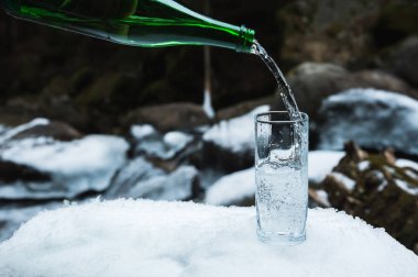 Mineral maden suyu yeşil cam şişeden açık cam kabı dökülür.