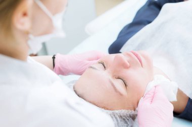 Bir close-up kozmetik ofis temizlik yordamı. Köpük ile cilt temizliği. Güzel kız güzellik salonu bulunan yüz temizlik yordamı. Dergi iş.