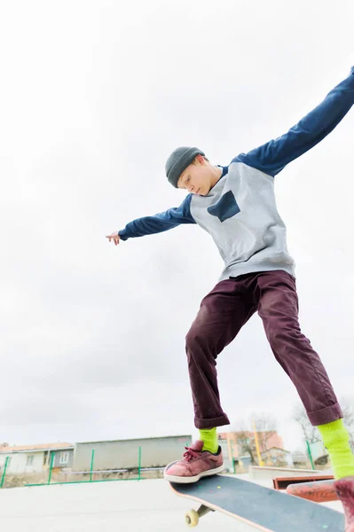 一个年轻的少年, 一个滑板, 在 skatepark 的栏杆上做一个把戏。城市文化中的青年体育观 — 图库照片