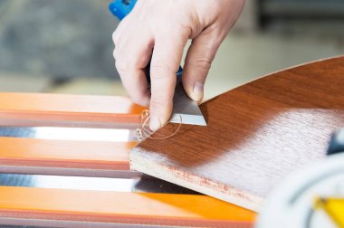 Yakın çekim gerçek erkek marangozlar değil bakımlı eller soyulmuş dekoratif bant kenarına kenar keserek Mobilya Sunta ayrıntılarını bitirmek tamamlar. ,