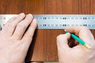 Okul mobilya için takımları jigsaw ve mobilya klipleri yanında kesmek için alt standart bir şablonla cetvelde bir kalem yakın çekim Mens el çizmek