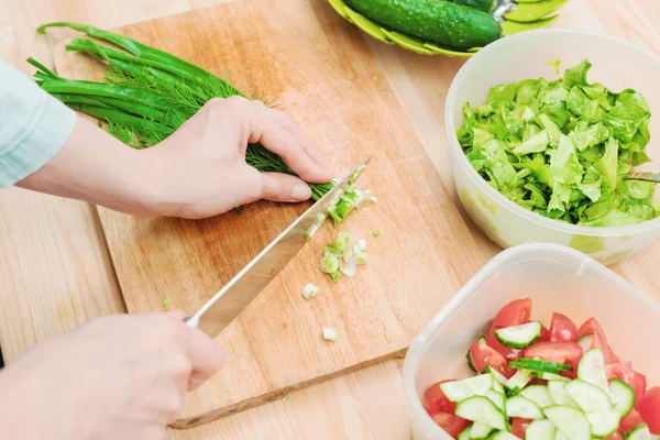 Yumuşak erkek Close-Up dilim ahşap tahta üzerinde SAP yeşil soğan salatası yapma eller. Kavramı bir vejetaryen sağlıklı gıda ve yaşam tarzı. Evde sağlıklı yemek yapma