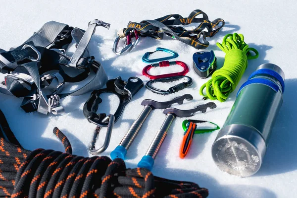 Närbild på vintern klättring utrustning på nysnö på en solig dag. Karbiner med ett rep lusthus och zhumar samt andra anpassningar när du tränar vintern bergsklättring. Året runt uppstigandet till — Stockfoto