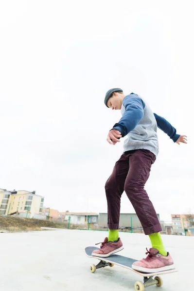 Der jugendliche Skateboarder fährt bei trübem Wetter über den Skatepark. Stadtkultur für junge Menschen. — Stockfoto