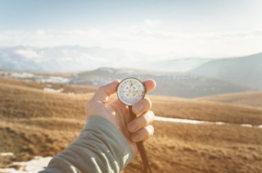 bir el tutar dağlar ve tepeler zemin karşı el bir pusula günbatımında mans. Seyahat ve açık alanlarda gezinti kavramı