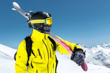 Koruyucu bir kask ve gözlük bir kayakçı büyük bir portresini bir maske ve eşarp ile Kafkasya karla kaplı dağlar omzundan kayaklar olduğunu. Kayak,