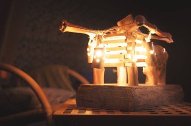 Arka farlı ahşap abajur ve gece yarısı kötü aydınlatılmış bir yatak odasında sallanan sandalye. Ev konforu