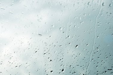 Her iki yağmur ve sisleme soyut görünümü, yağmur damlaları mavi cama cam ve bulanık manzara mavi ve yeşil geçişin üzerinde doğal arka plan damla