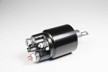 Gri eğimli arka planı olan bir araba için yeni siyah bobin. Otomobil parçaları. Başlangıç Bölümleri