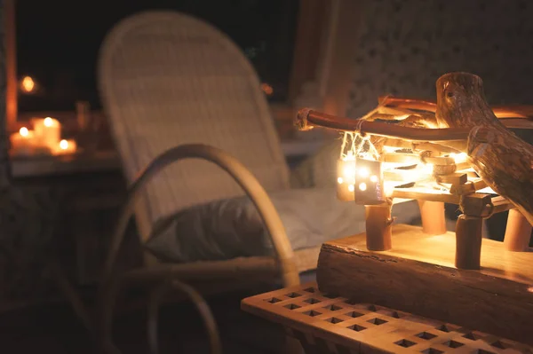 Lâmpada de madeira close-up com luz de fundo e cadeira de balanço em um quarto mal iluminado à noite. Conceito de conforto doméstico — Fotografia de Stock