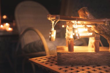 Arka farlı ahşap abajur ve gece yarısı kötü aydınlatılmış bir yatak odasında sallanan sandalye. Ev konforu