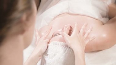 Kapalı Spa yüz masajı. Profesyonel masaj terapisti çekici bir spa salonu müşterisine yüz masajı yapıyor.