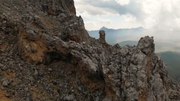 Close-up Aerial view of a drone flying through sharp rocky outcrops at sunset. Sharp steep mountain of rock formations for extreme mountaineering. Flight over travel video — Stock Video