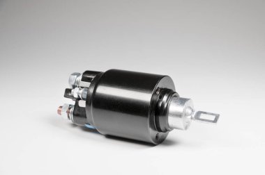 Gri eğimli arka planı olan bir araba için yeni siyah bobin. Otomobil parçaları. Başlangıç Bölümleri