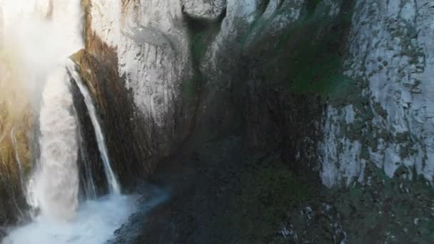 Kafkasya 'daki dik bir uçurumdan devasa bir şelalenin havadan görünüşü. Dağlarda geniş bir su akıntısına yakın çekim. Kafkas İzlanda — Stok video