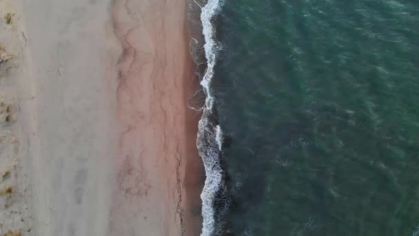 Vista aérea de uma tecla baixa Um vídeo sobre uma praia tropical a uma hora azul após o pôr-do-sol mostrando imagens noturnas de ondas verdes do oceano espumantes colidindo com a costa. Vista superior sem pessoas — Vídeo de Stock