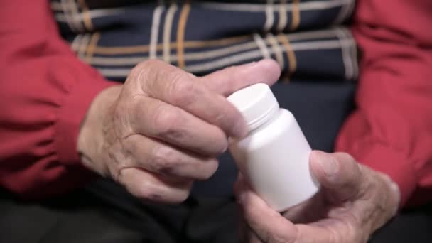 Hände einer alten Frau, die ein weißes Glas mit Omega-3-Medikamentenkapseln und Vitaminen öffnet. Gesundheitskonzept ergänzt Pillen und Vitamine — Stockvideo