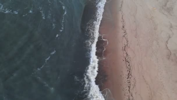 Vista aérea de uma tecla baixa Um vídeo sobre uma praia tropical a uma hora azul após o pôr-do-sol mostrando imagens noturnas de ondas verdes do oceano espumantes colidindo com a costa. Vista superior sem pessoas — Vídeo de Stock