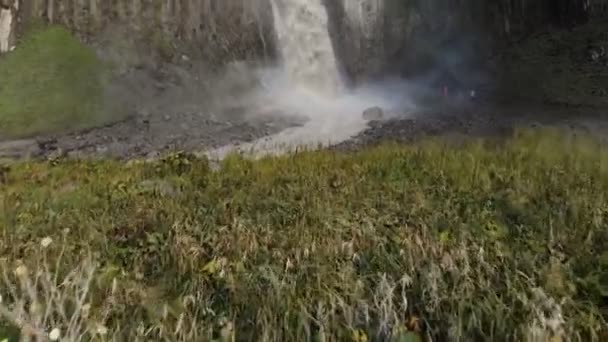 Kafkasya 'daki dik bir uçurumdan devasa bir şelalenin havadan görünüşü. Dağlarda geniş bir su akıntısına yakın çekim. Kafkas İzlanda — Stok video