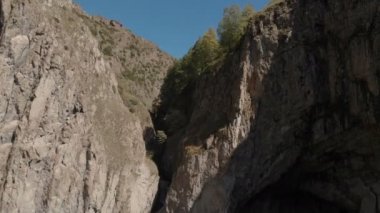 Kafkasya 'daki dik bir uçurumdan devasa bir şelalenin havadan görünüşü. Dağlarda geniş bir su akıntısına yakın çekim. Kafkas İzlanda