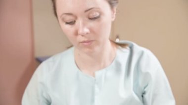 Kapalı Spa yüz masajı. Profesyonel masaj terapisti çekici bir spa salonu müşterisine yüz masajı yapıyor.