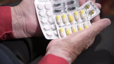 Yaşlı bir kadının elinde bir tabletin kapanışı. Yaşlılıkta ilaç seçme kavramı