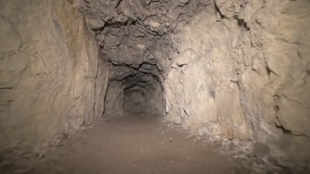 Speleologia keinotekoinen luola tumma tunneli kaivaminen maan alla. Vanha adit metallin ja kivien louhintaa varten — kuvapankkivideo