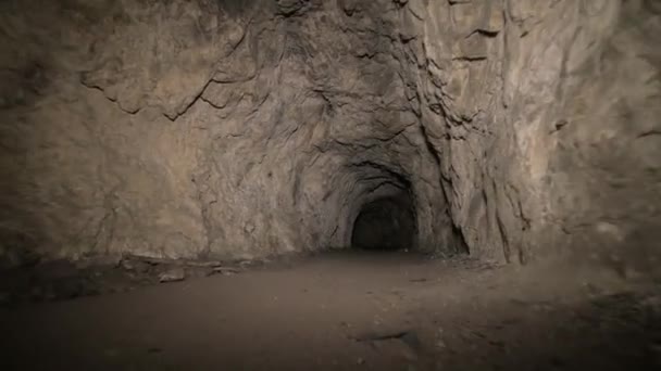 Спелеология искусственная пещера темный туннель раскопки под землей. Старый причал для извлечения металла и камней — стоковое видео