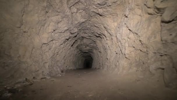 Спелеология искусственная пещера темный туннель раскопки под землей. Старый причал для извлечения металла и камней — стоковое видео