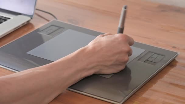 Egy férfi tervező közelképe rajzol a laptopjára segítséggel. grafikus tabletta és toll stylus — Stock videók