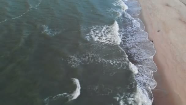 Vue aérienne d'une plage tropicale à l'heure bleue après le coucher du soleil montrant des images en soirée de vagues océaniques vertes mousseuses s'écrasant sur la côte. Vue de dessus sans personnes 