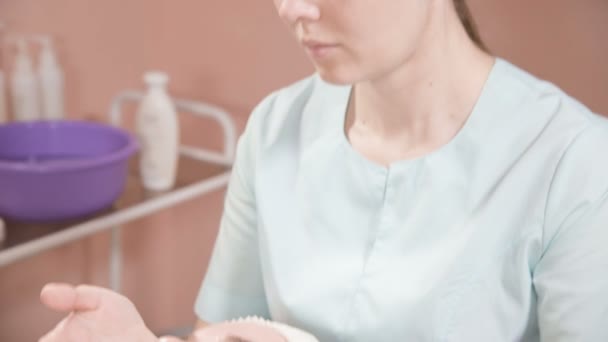 Esthéticienne dans un masque et des gants fait un massage du visage salubre à une femme attrayante. Massage cosmétologie nouvelle génération — Video