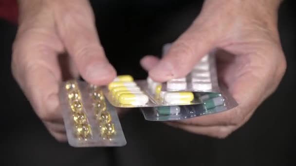Egy tabletta közelsége egy idős nő kezén. Az időskori gyógyszerválasztás koncepciója — Stock videók