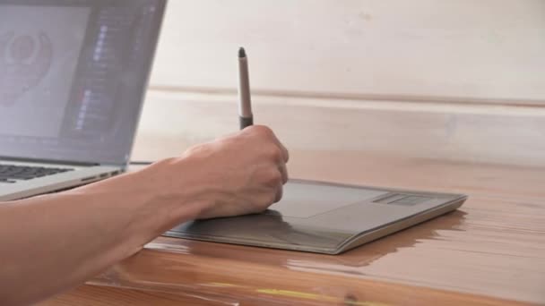 Close-up van een mannelijke ontwerper trekt met hulp op zijn laptop. grafische tablet en pen stylus — Stockvideo