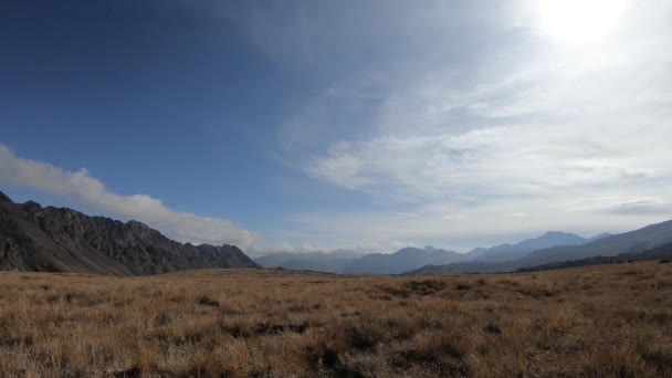 Po modré obloze se nad zasněženými vrcholky hor, Georgií, Kavkazem, táhly mraky. Horské údolí, příroda Gruzie, Kazbegi. Mraky ve skalnatých horách — Stock video