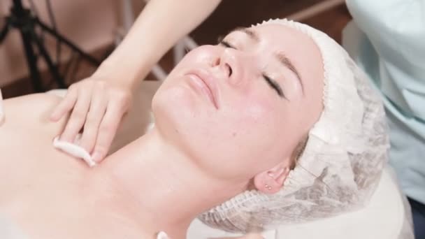 Fata cosmetician într-o mască și mănuși face un masaj facial salubru pentru o femeie atractivă. Masaj cosmetologic de noua generatie — Videoclip de stoc