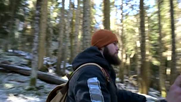 Junger Mann mit Bart und Rucksack im Winterwald. Kameraschwenks 360, Nahaufnahme. — Stockvideo