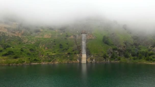 Hava saldırısı dronu. Dağlardaki göl. Bulutlar yeşil tepeleri kaplıyor. — Stok video