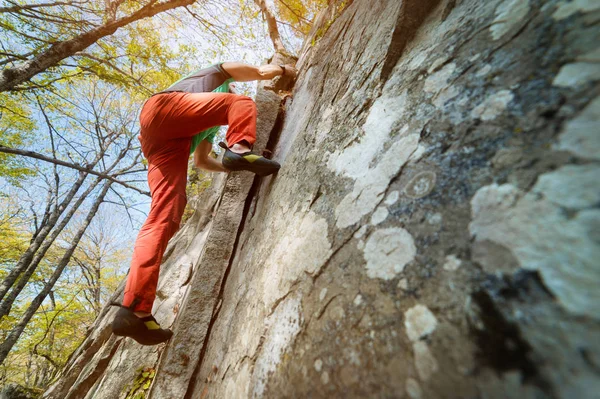 Na ścianie skalnej w lesie w górach wisi wolny, stary wspinacz. Koncepcja dojrzałego sportu — Zdjęcie stockowe