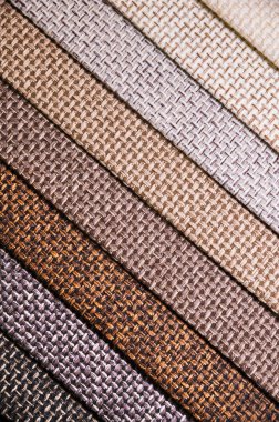 Mobilya ve giysi döşemelerinin renkli ve parlak kumaş örnekleri. Farklı renklerdeki tekstil soyut çapraz çizgilerinin paletinin yakın plan görüntüsü