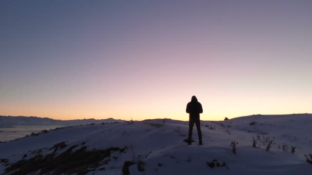El hombre controla el dron de disparo. Hermoso paisaje nevado. Invierno, Cáucaso, puesta del sol — Vídeos de Stock