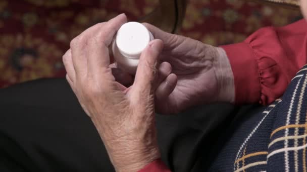 Omega-3 ilaç kapsülleri ve vitaminlerle beyaz bir kavanozu açan yaşlı bir kadının elleri. Sağlık konsepti hapları ve vitaminleri destekliyor — Stok video