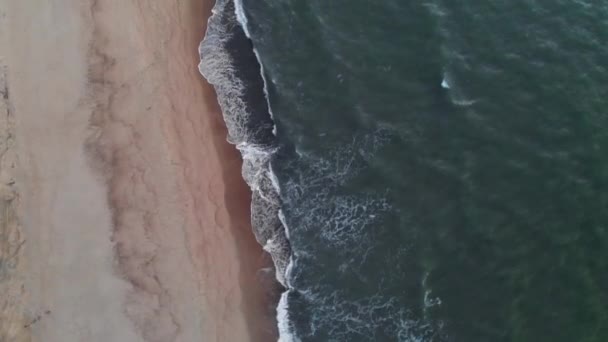 Εναέρια άποψη ενός χαμηλού κλειδιού Ένα βίντεο για μια τροπική παραλία σε μπλε ώρα μετά το ηλιοβασίλεμα που δείχνει το βράδυ πλάνα από πράσινα αφρώδη κύματα του ωκεανού να συντρίβονται στην ακτογραμμή. Κάτοψη χωρίς ανθρώπους — Αρχείο Βίντεο
