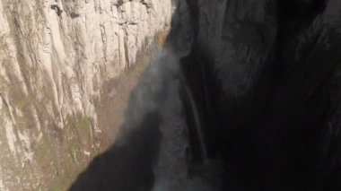 Kafkasya 'daki dik bir uçurumdan devasa bir şelalenin havadan görünüşü. Dağlarda geniş bir su akıntısına yakın çekim. Kafkas İzlanda