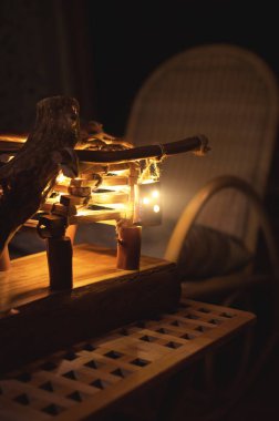 Arka farlı ahşap abajur ve gece yarısı kötü aydınlatılmış bir yatak odasında sallanan sandalye. Ev konforu