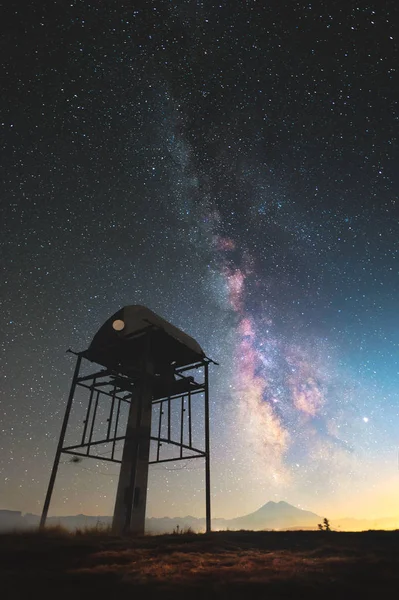 Noční krajina hvězdnaté oblohy a Mléčné dráhy s telekomunikační věží pro přenos wifi v horách na pozadí hory Elbrus na severním Kavkaze — Stock fotografie