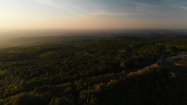 Tir de drone. Paysage forestier, vallée. Tour radio au sommet de la colline. Coucher de soleil .