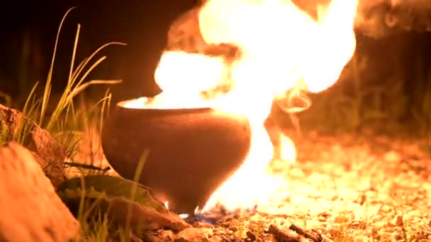 暗闇の中で鍋に炎。火が周りを照らす。夏も鍵も鍵もかけない — ストック動画