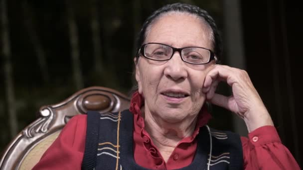 안경을 쓴 할머니가 실내에 앉아서 생각하고 있는 모습. 80 세 노인 — 비디오